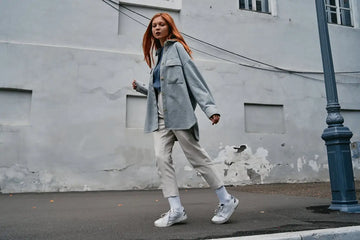 a woman with red hair walking down the street