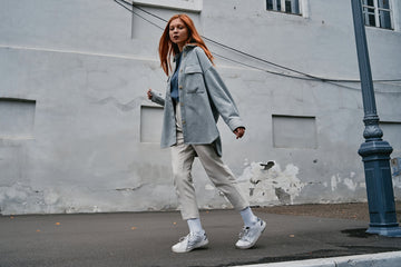 a woman with red hair walking down the street