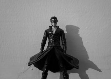 a black and white photo of a man in a leather outfit
