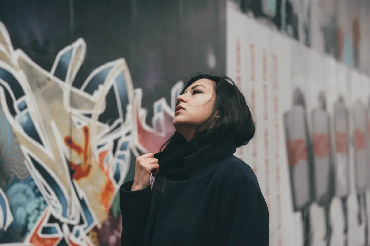 woman wearing black drawstring hoodie near concrete wall