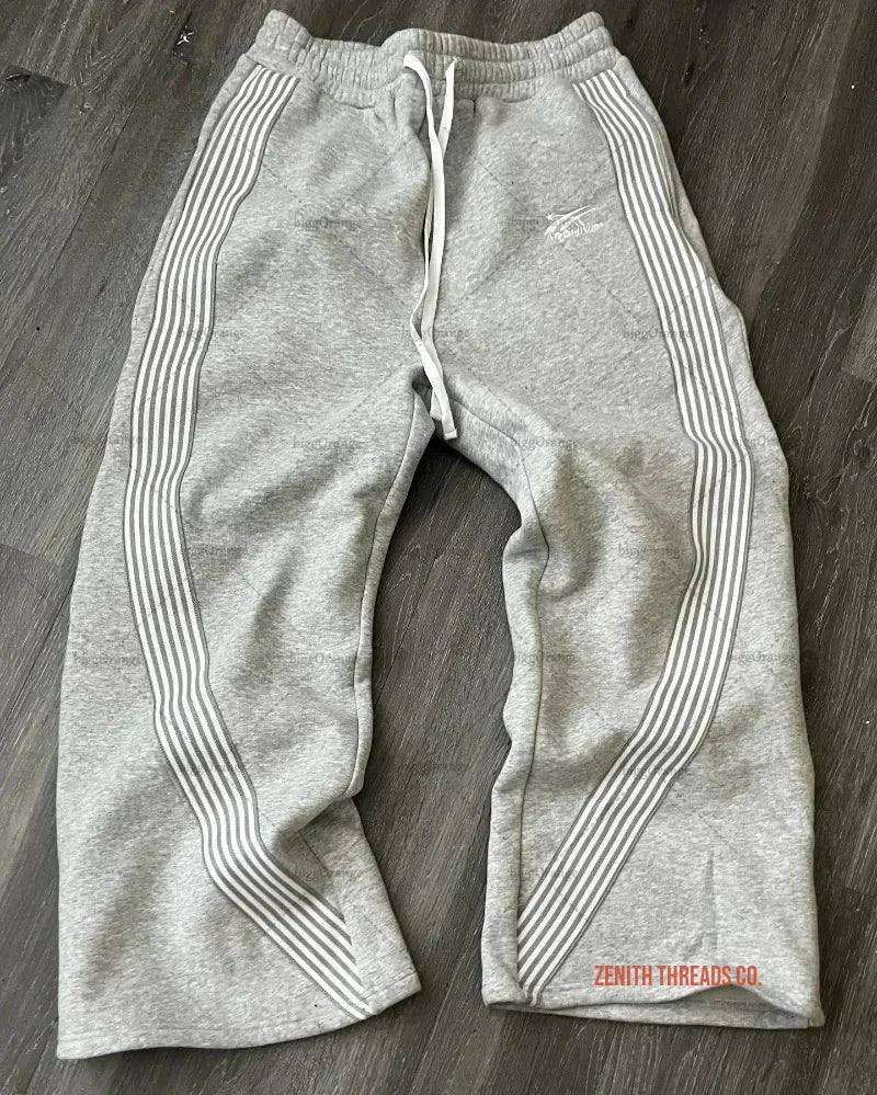 Gray Nike sweatpants with striped side panels and drawstring waist.