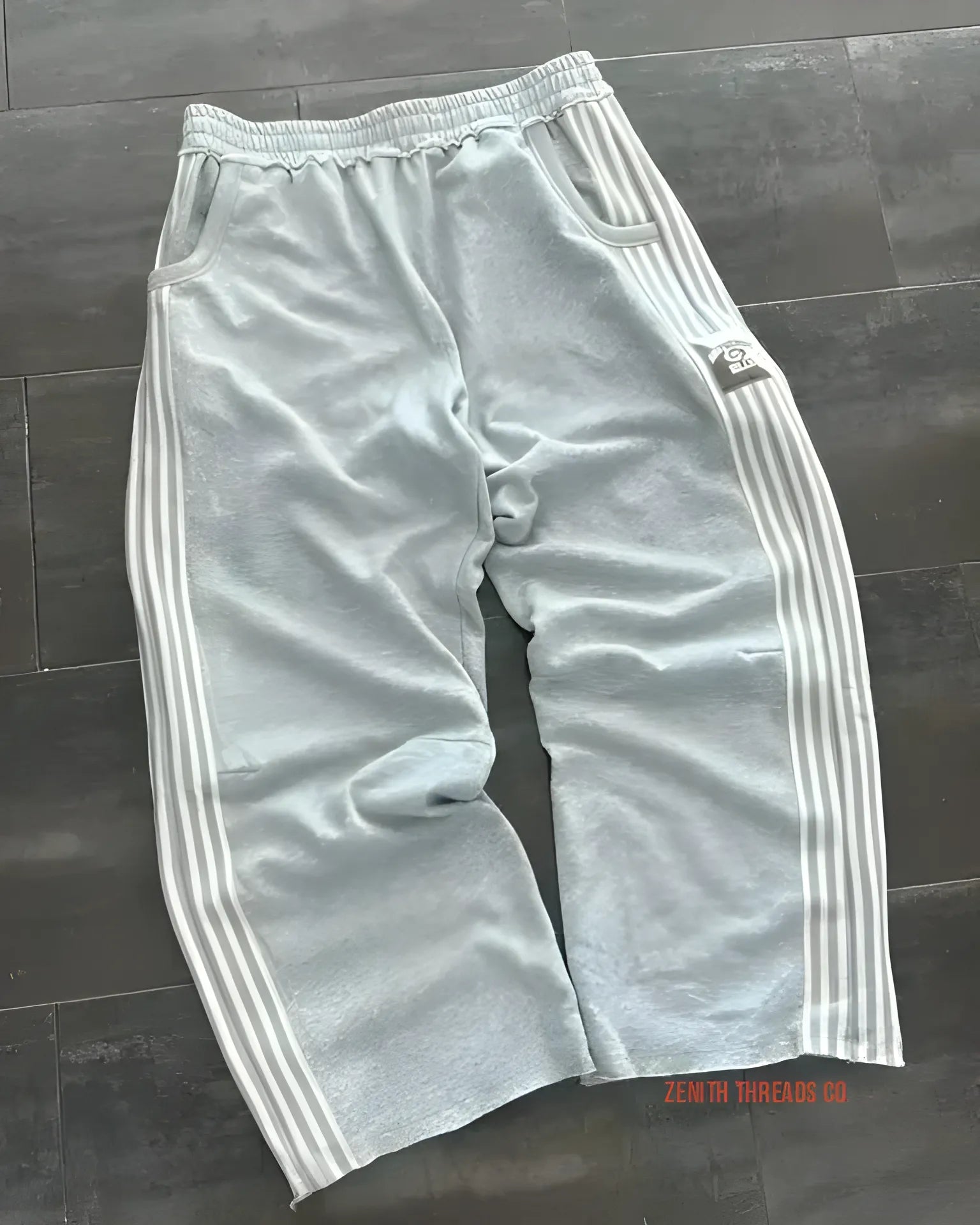 Gray Adidas track pants with white stripes down the sides.