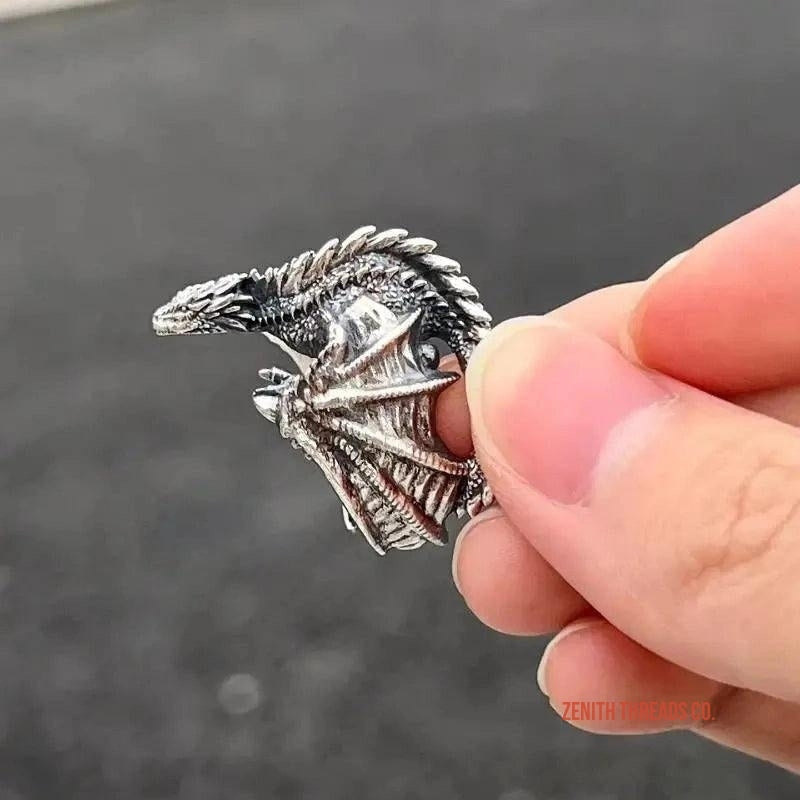 Detailed silver dragon ring with an open mouth and blue gemstone eye.