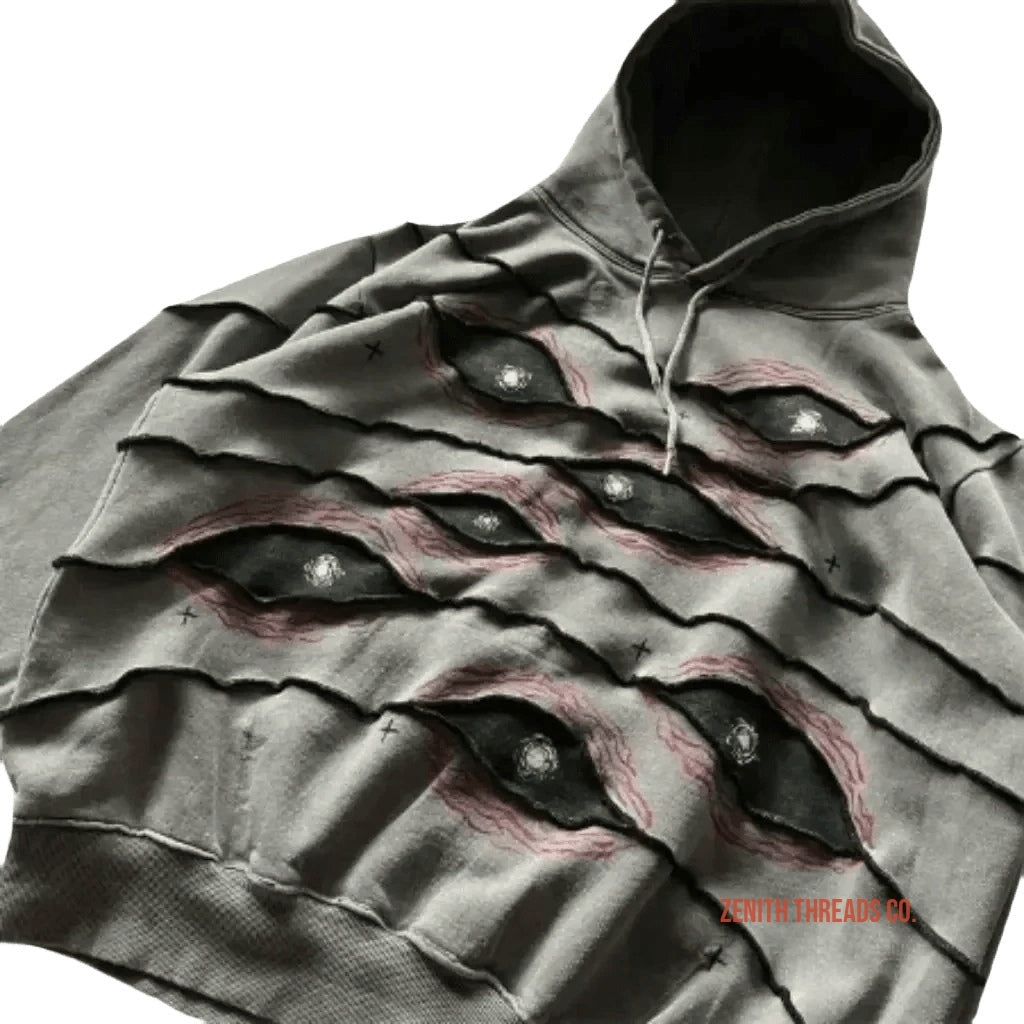 Grey hoodie with layered fabric designed to look like eyes peering through torn slashes.