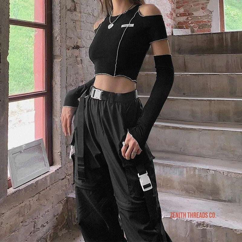 Black techwear outfit featuring a cropped top with arm warmers and cargo pants with utility pockets.