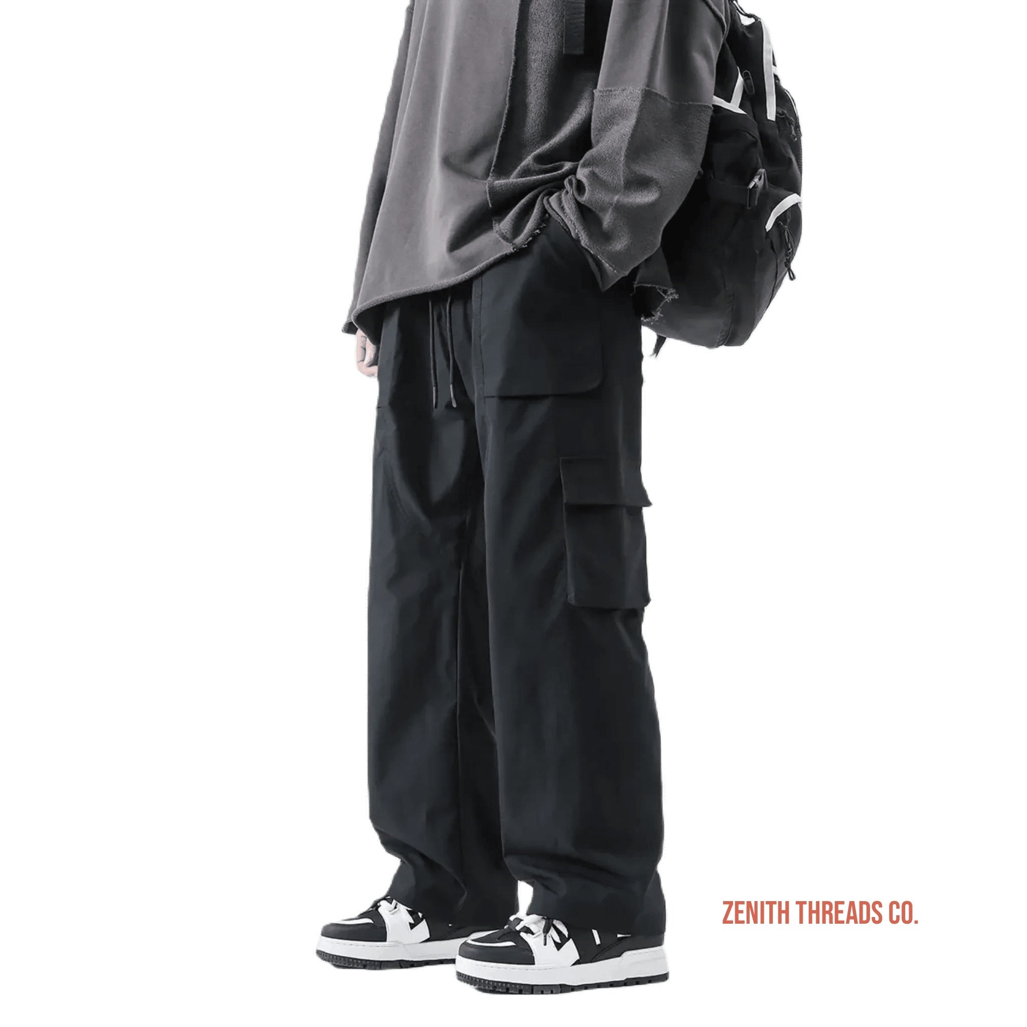 Black cargo pants with multiple side pockets worn with sneakers.