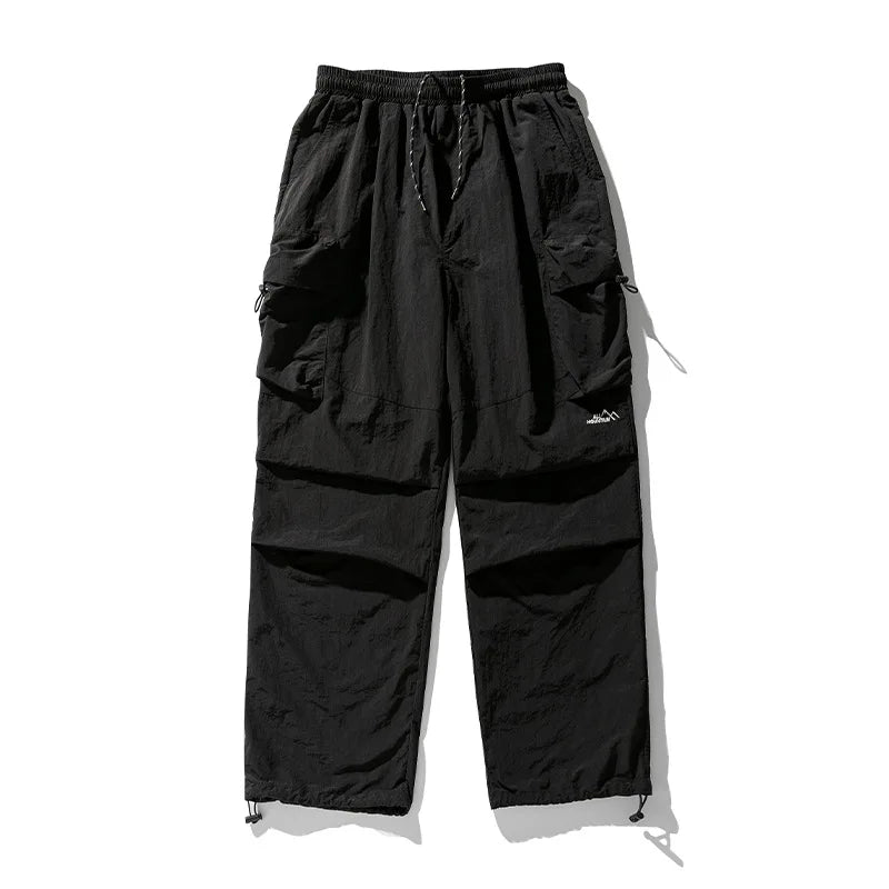 Black cargo pants with drawstring waist and multiple pockets.