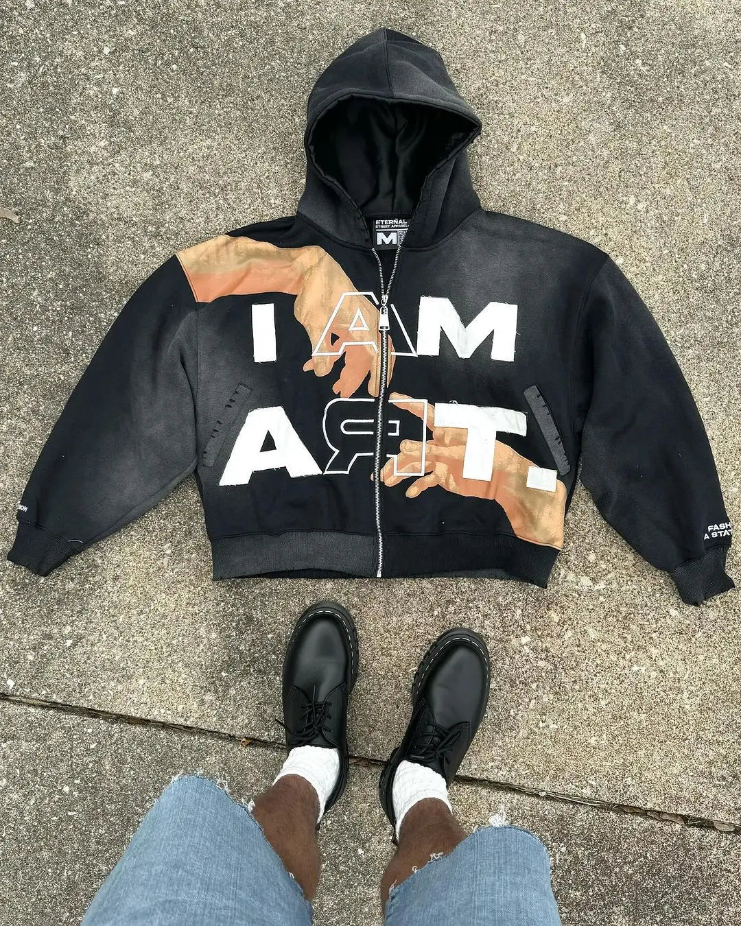 Black cropped hoodie with ’I AM’ text and brown graphic design elements.