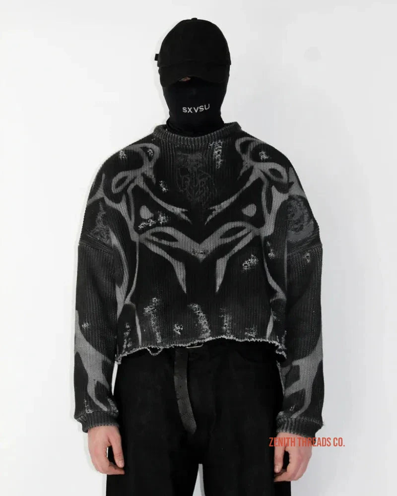 Black and grey patterned cropped jacket worn with a face mask and dark pants.