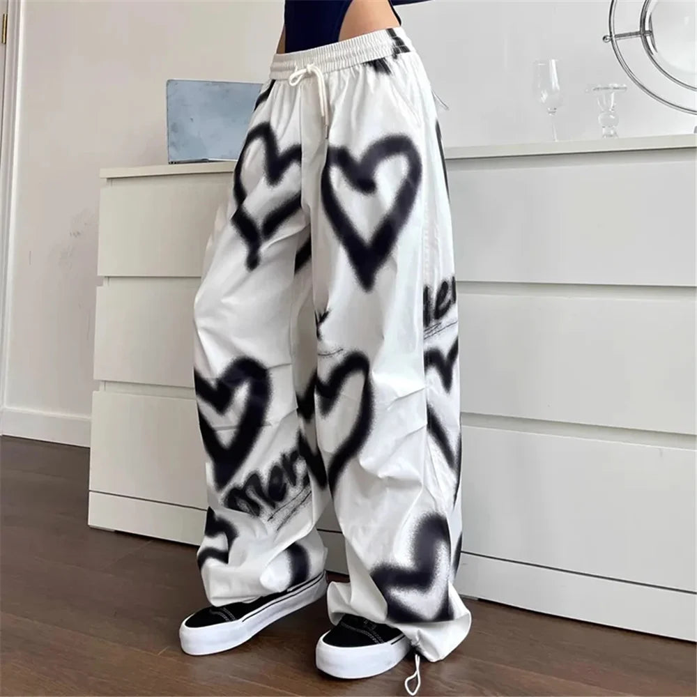 White sweatpants with black spray-painted heart designs.