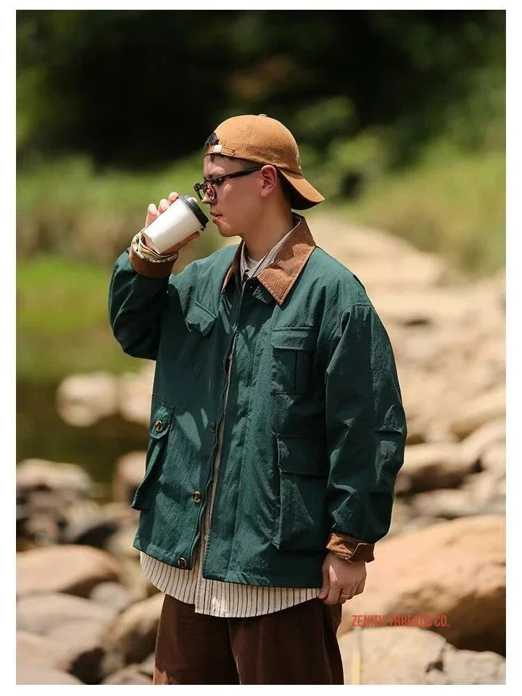 Someone wearing a green work jacket and brown baseball cap drinking from a cup.