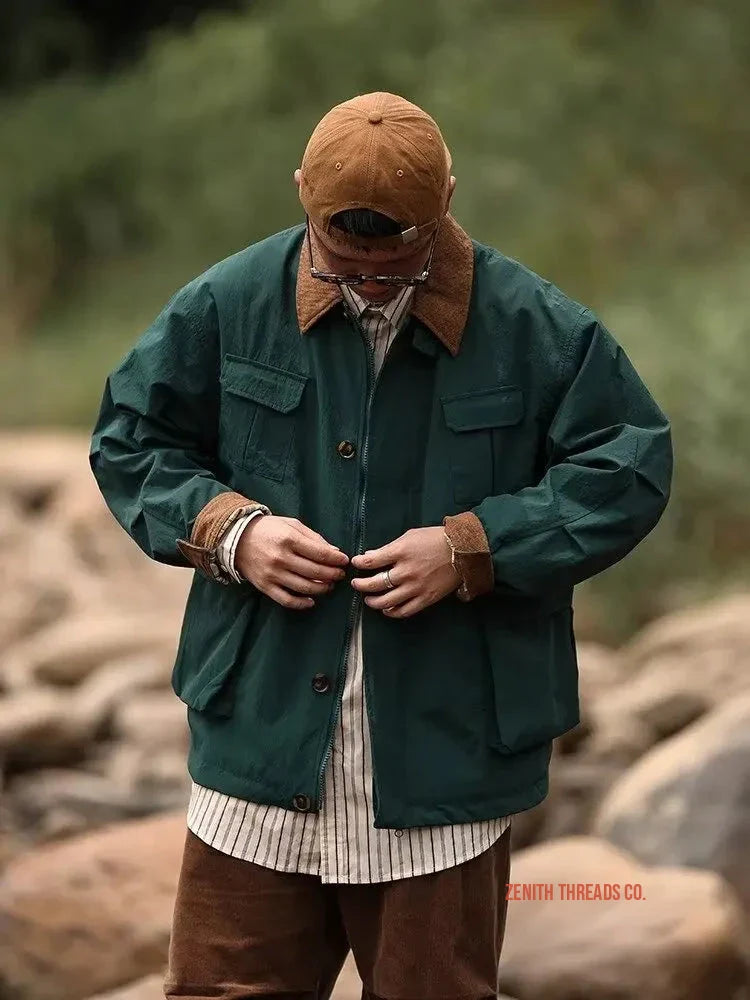 Green workwear jacket with brown corduroy collar worn over a striped shirt.