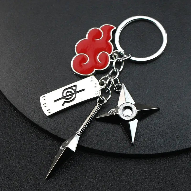 Naruto-themed keychain featuring the Akatsuki cloud symbol, ninja headband, kunai weapon, and shuriken throwing star charms.