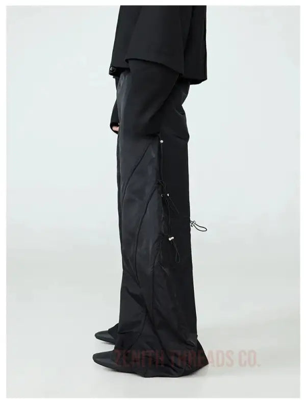 Black cargo pants with side pockets and drawstring details.