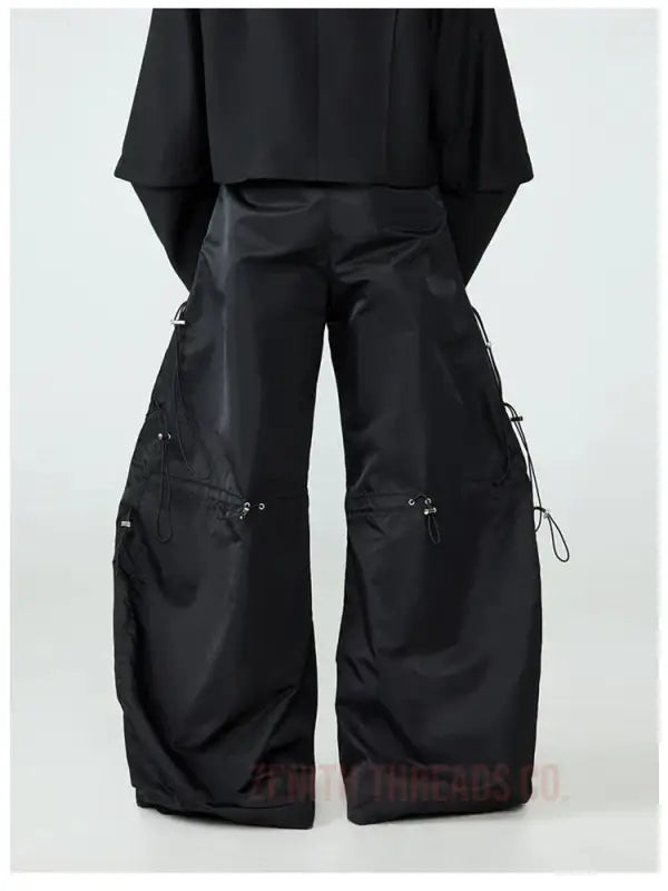 Black wide-leg cargo pants with side pockets and drawstring details.