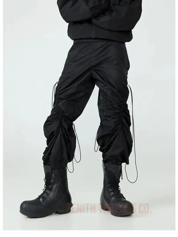 Black cargo pants with drawstring details tucked into combat boots.