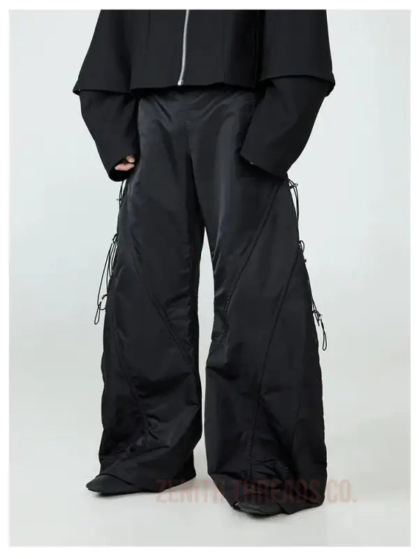 Black wide-leg cargo pants with side straps and pockets.