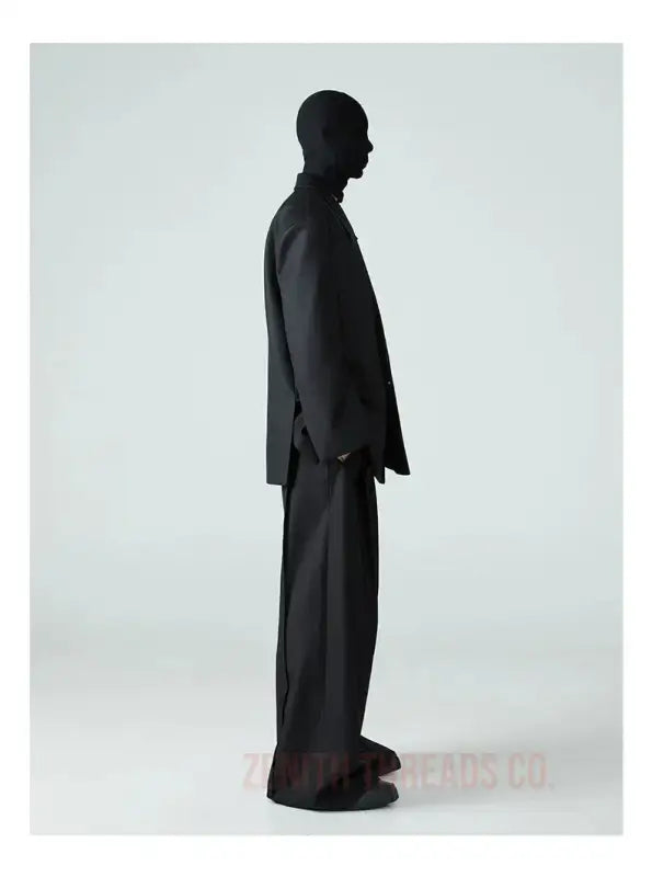 Silhouetted figure standing in profile wearing a formal suit.