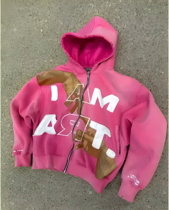 Pink zip-up hoodie with ’I AM ASRT’ text and brown patches.