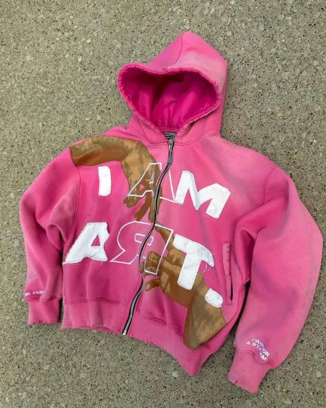 Pink zip-up hooded sweatshirt with ’DAM ASST’ text and brown accents.