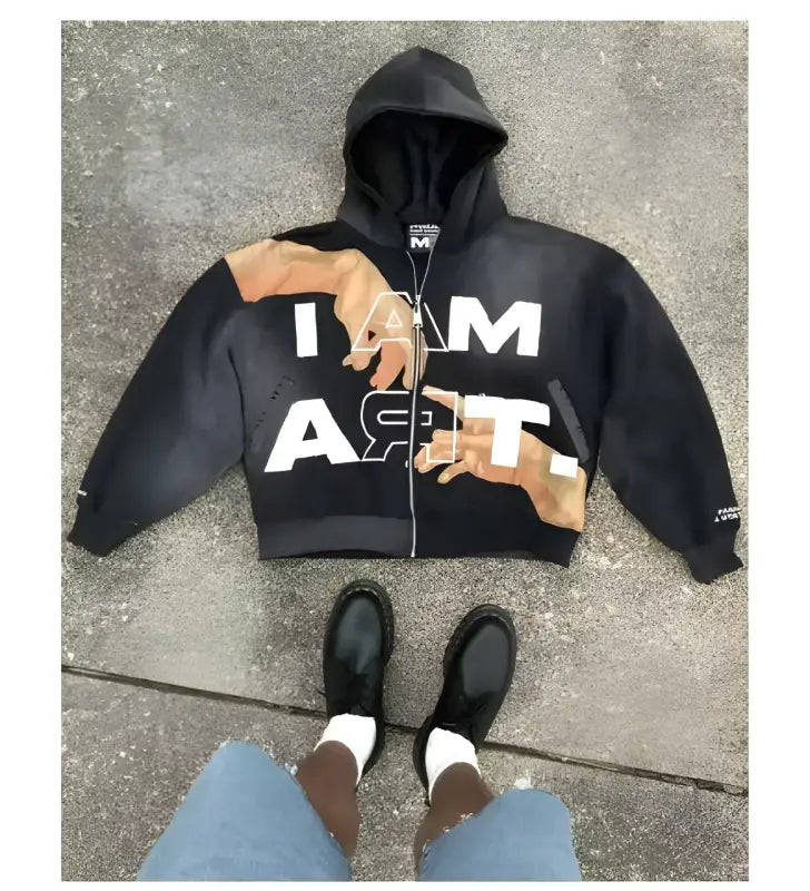 Black zip-up hoodie with ’I AM’ text and brown design accents.