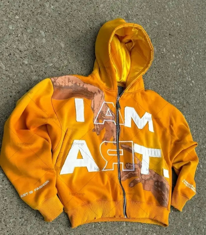 Orange zip-up hoodie with ’I AM ART’ text printed on it.