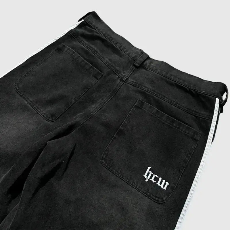 Black denim pants with ’hcw’ text embroidered on the back pocket.