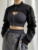 Woman wearing a black cropped zip-up collar safari streetwear jacket with gray pants