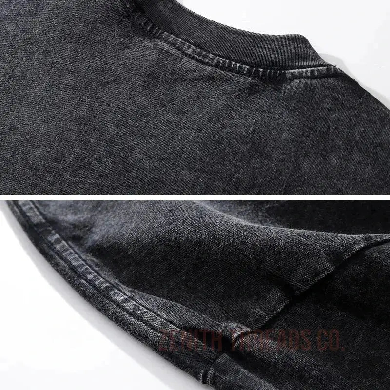 Faded black denim fabric with visible stitching detail.