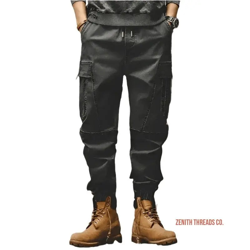 Black cargo jogger pants with elastic cuffs worn with tan work boots.