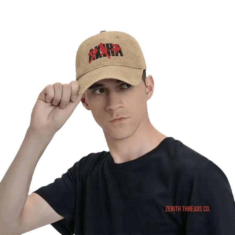 Tan baseball cap with red ’Akira’ text logo worn by someone in a black t-shirt.