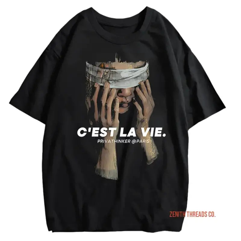 Black t-shirt with hands holding a bandaged face graphic and ’C’EST LA VIE’ text.