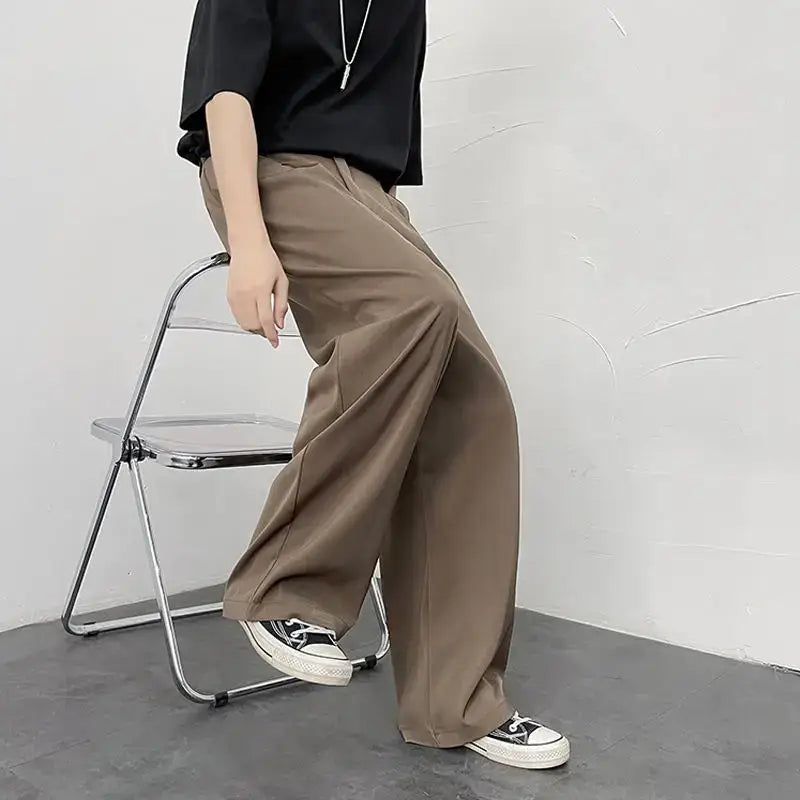 Wide-leg khaki trousers paired with black sneakers.