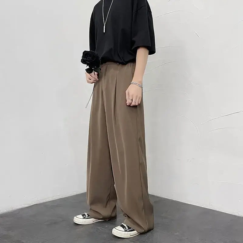 Wide-leg khaki trousers paired with a black t-shirt and white sneakers.