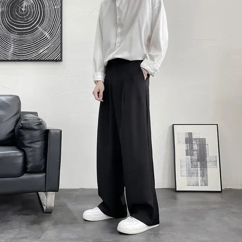 Wide-leg black dress pants paired with a white button-down shirt and white sneakers.