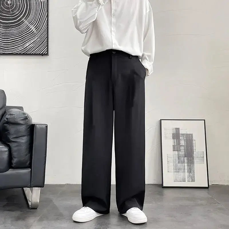 Wide-leg black dress pants paired with a white button-down shirt and white sneakers.