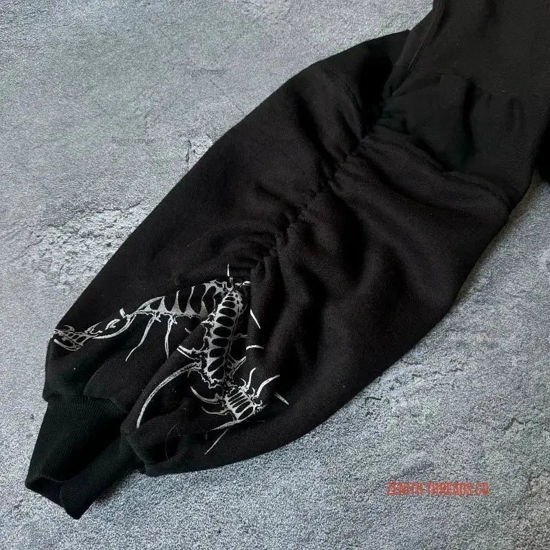 Black sweatpants with a white dinosaur skeleton design on the leg.