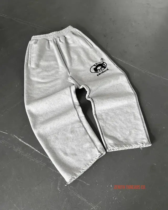 Gray sweatpants with a black logo emblem on the side.