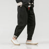 Black drawstring pants with white trim complement a Timeless Chinese style jacket