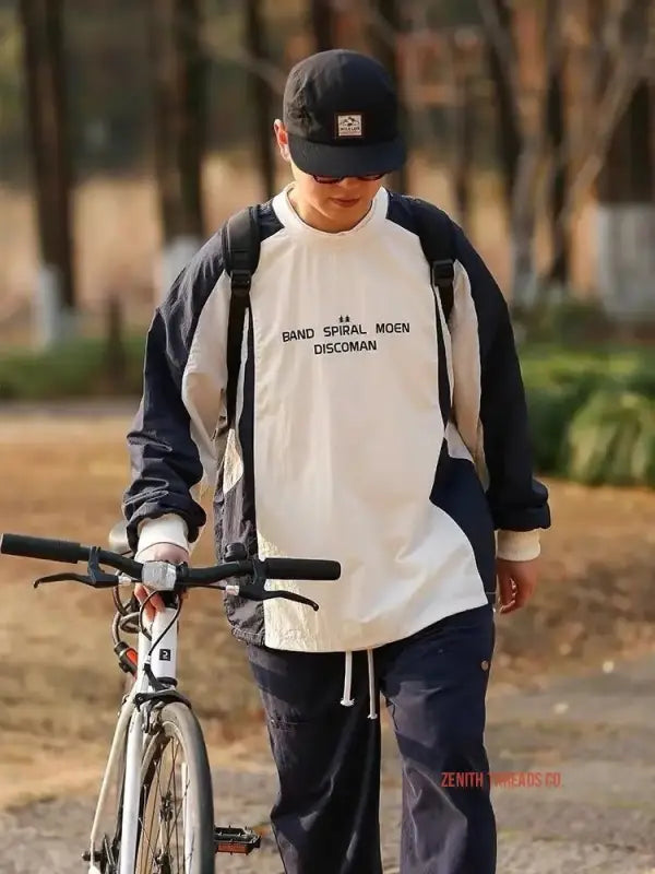 A person wearing a baseball cap and white t-shirt stands next to a bicycle.