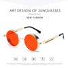 Round orange-tinted sunglasses with gold frames for metal steampunk techwear enthusiasts