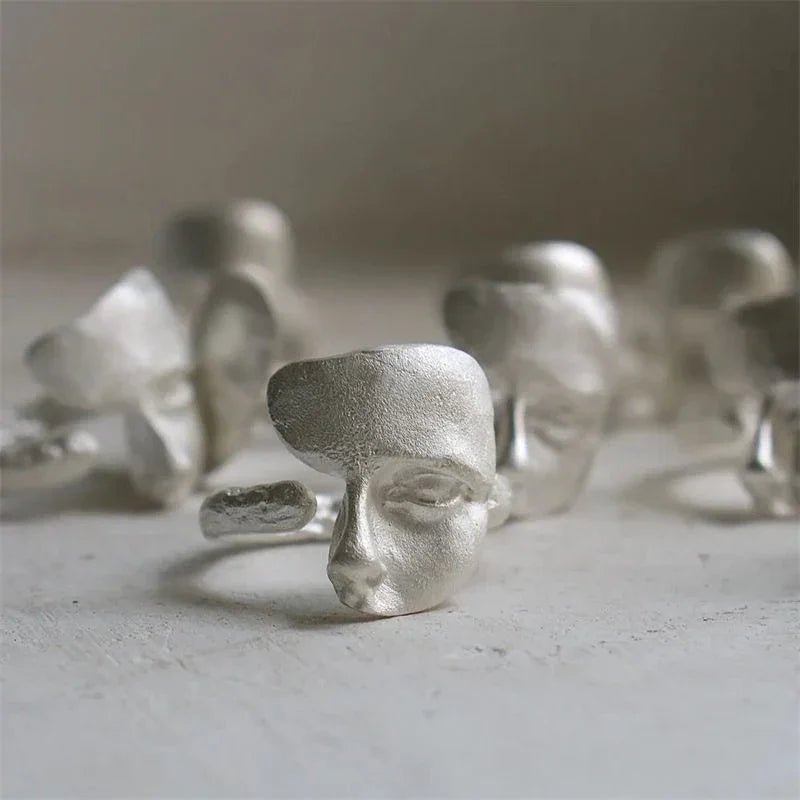 Silver masked faces ring with adjustable open-band and elegant metal finish