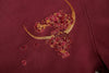 Burgundy fabric with floral and crescent moon embroidery on a mythical dragon embroidered hoodie