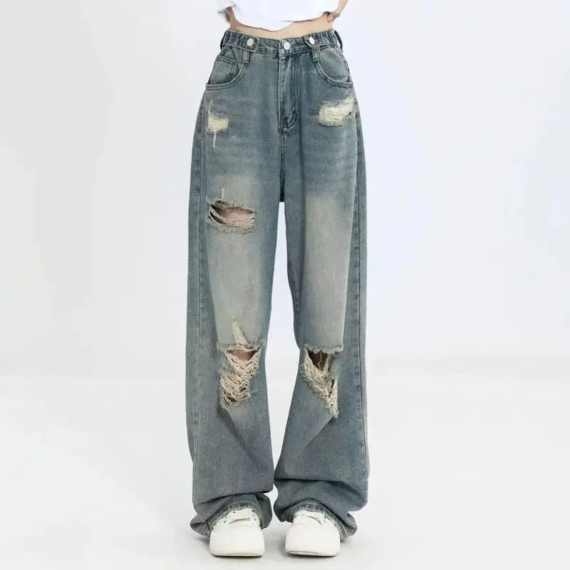 Distressed light-wash denim jeans with ripped holes and a baggy fit.