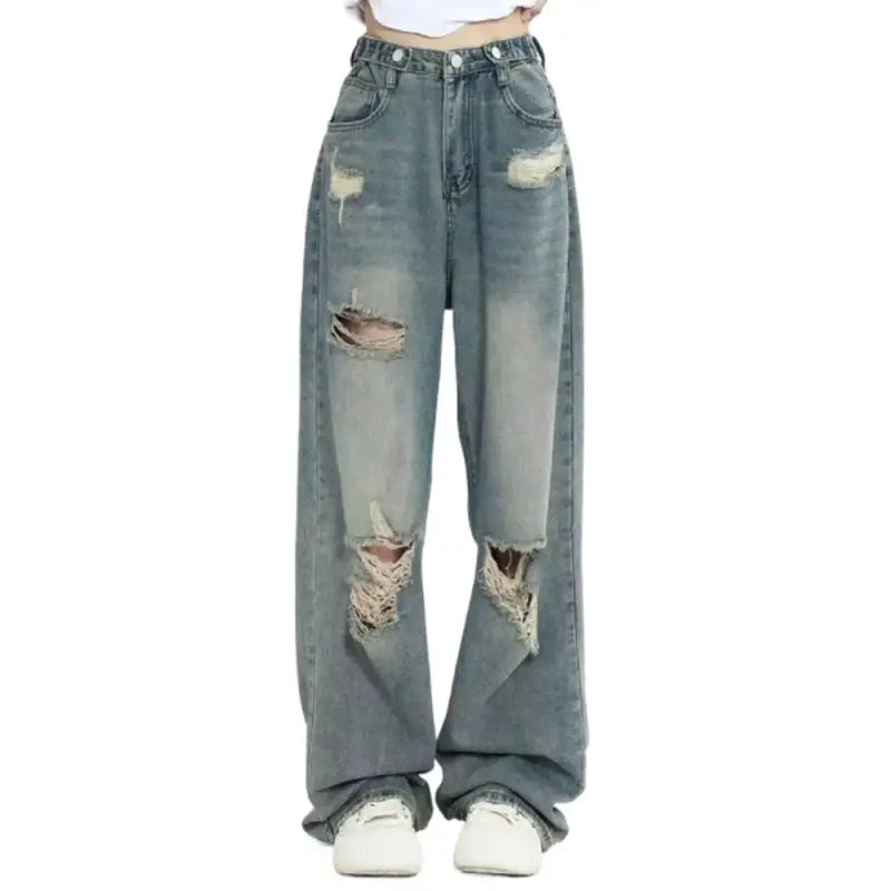 Distressed light blue baggy jeans with ripped holes in the knees and thighs.