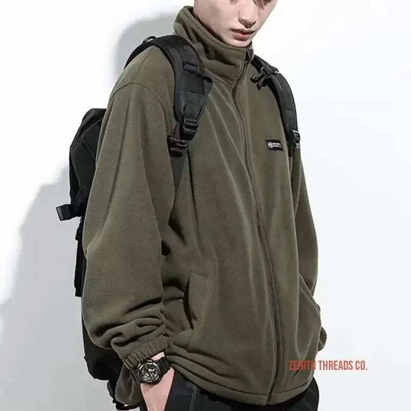 Olive green fleece jacket with a high collar and black backpack straps.