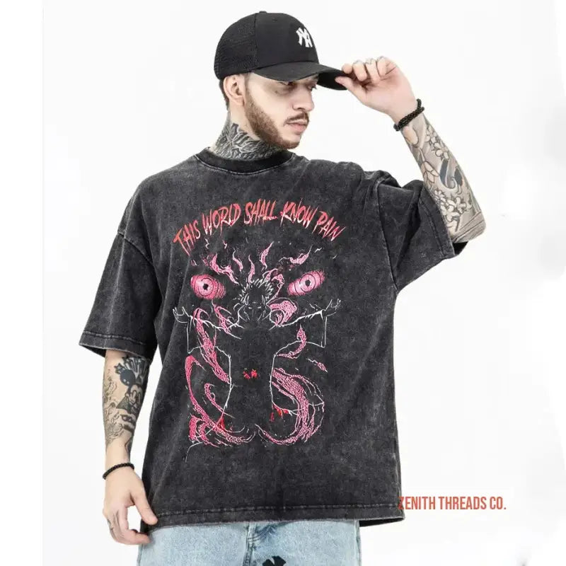 Black vintage-style t-shirt featuring pink demonic artwork and text reading ’THIS WORLD SHALL KNOW PAIN’