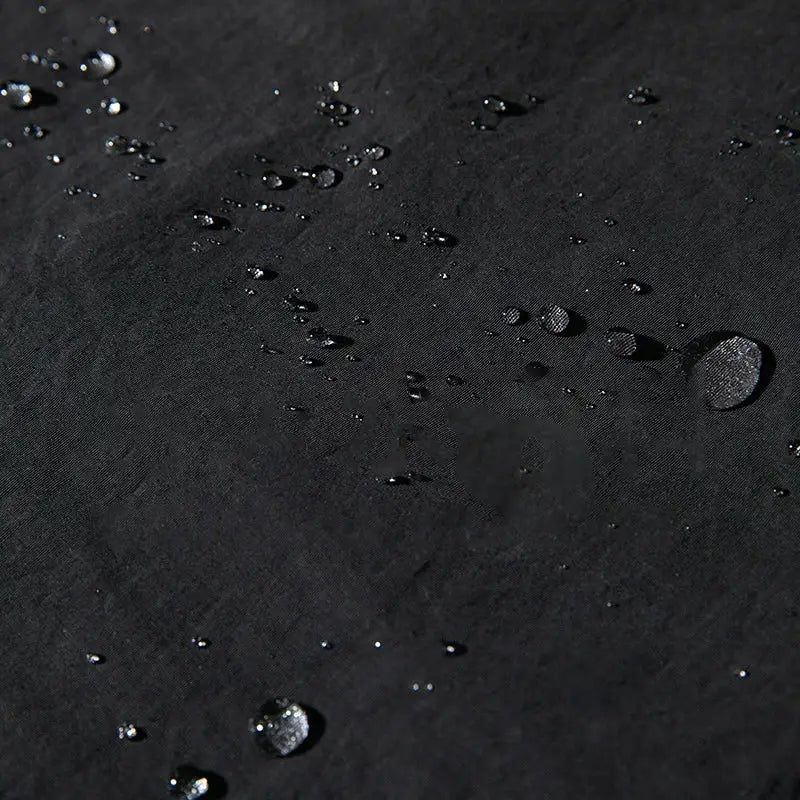 Water droplets scattered on a dark surface.