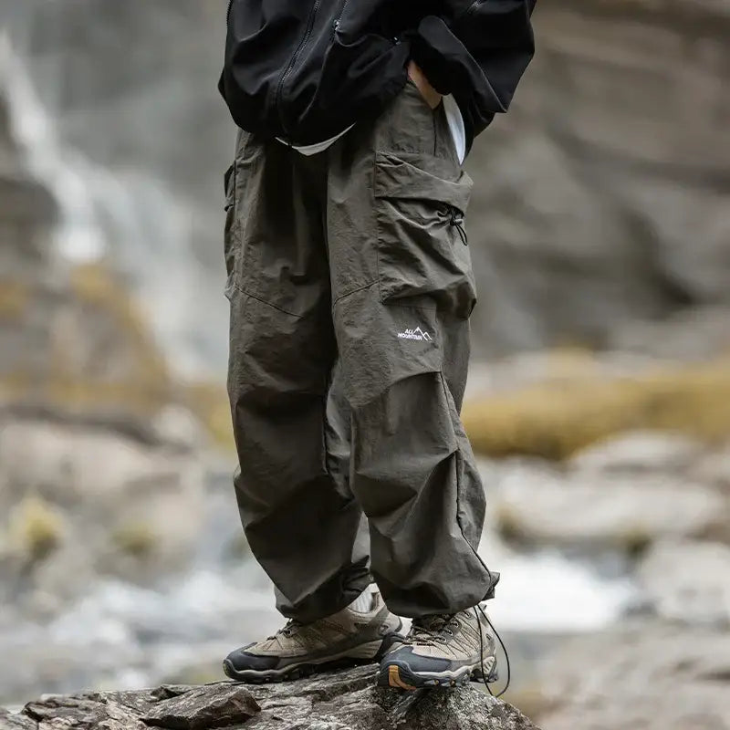 Olive green cargo pants with multiple pockets worn with hiking boots.