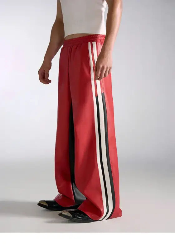 Red athletic pants with black and white side stripes.